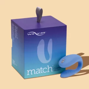 The We-Vibe Match Couples Vibrator in blue next to its purple and blue retail box, showing the main product and packaging. Available at TheSexToysIndia.