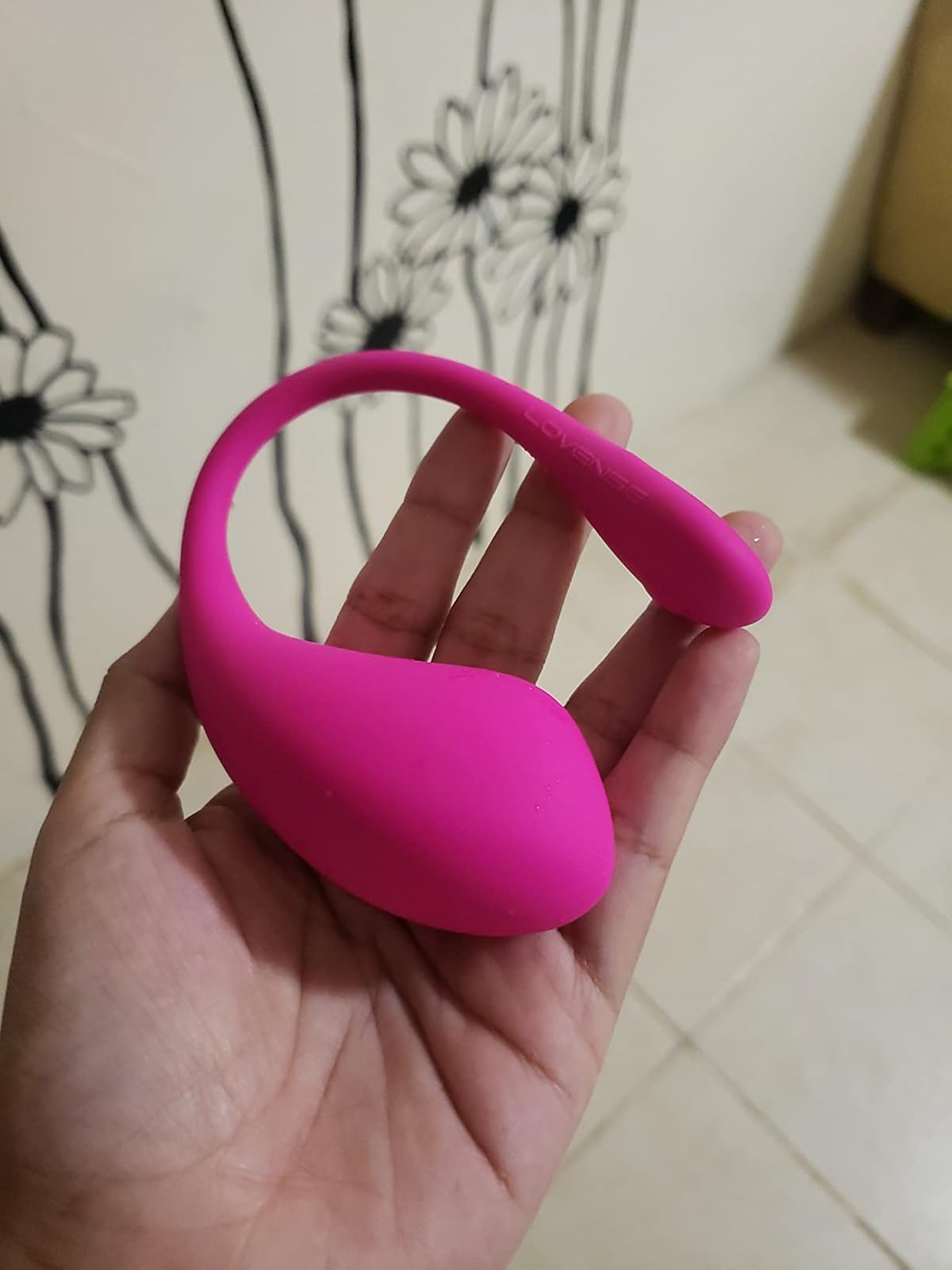 Lovense Lush 3 pink app controlled egg vibrator held in hand showing flexible tail design and silicone finish
