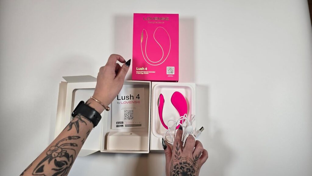 Lovense Lush 4 unboxing showing packaging box, egg vibrator, charging cable and accessories laid out